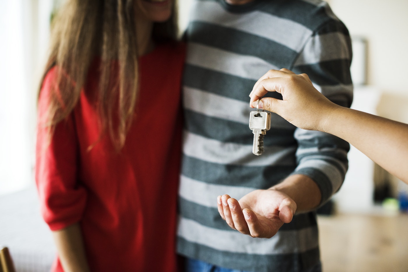 a couple getting a key to a new house